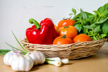 Organic vegetables in the wicker basket on wooden background