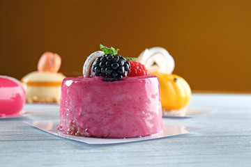 Tasty berry mousse cake on wooden table