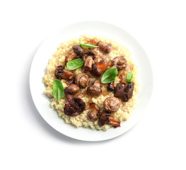 Plate with tasty risotto and mushrooms on white background