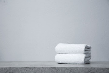 Stack of towels on table against grey background