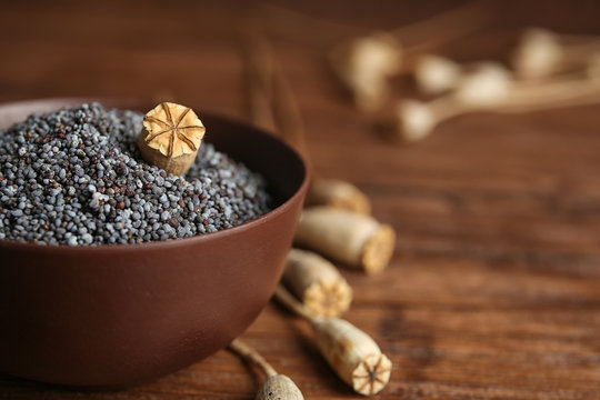 Bowl with poppy seeds on table, closeup