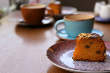 Plate with slice of carrot cake on wooden table
