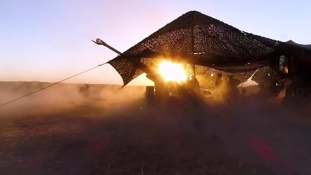 Soldiers fire heavy artillery in the battlefield.