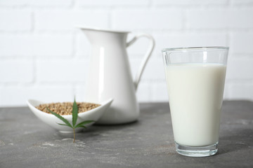 Glass of hemp milk on grey table