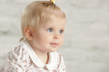 Portrait of a cute baby girl sitting in the room