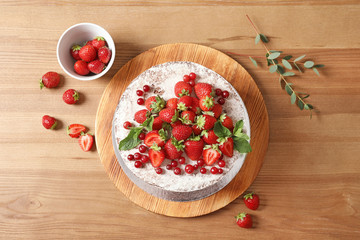 Delicious homemade cake with fresh berries on wooden table, top view