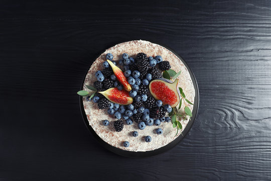 Delicious homemade cake with fresh berries on dark wooden table, top view
