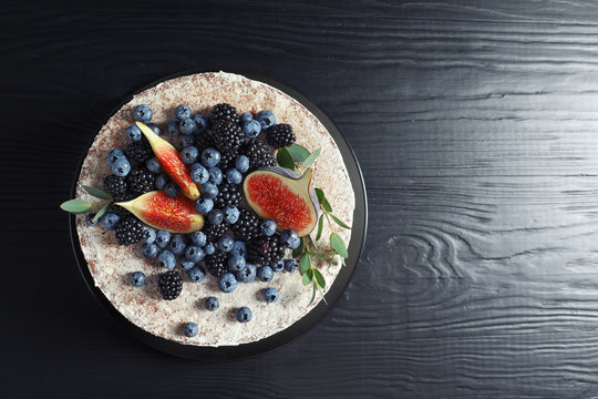 Delicious homemade cake with fresh berries and space for text on dark wooden table, top view