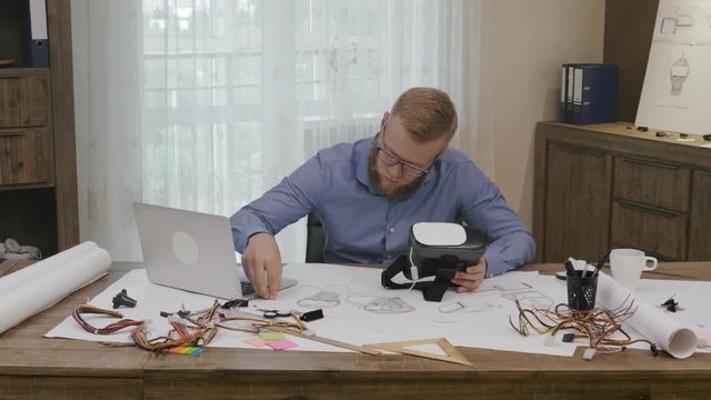 Software engineer programming VR headset