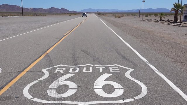 Establishing shot of a lonely desert highway in Arizona with Route 66 painted on the pavement.