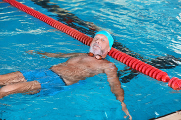 Sportive senior man in indoor swimming pool