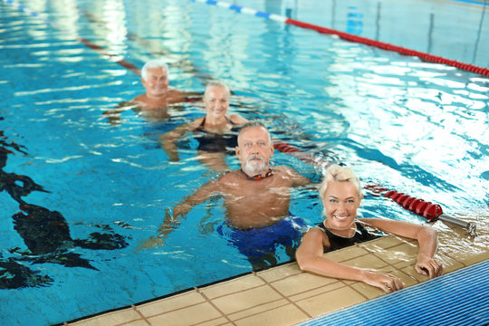 Sportive senior people in indoor swimming pool