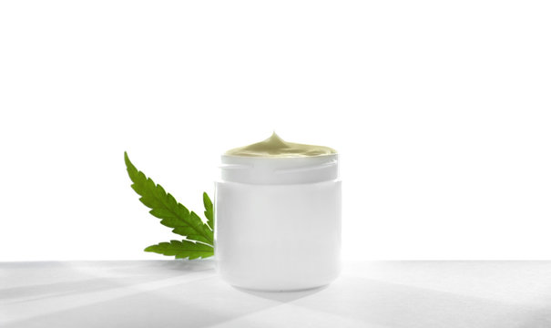 Jar with hemp lotion on white background