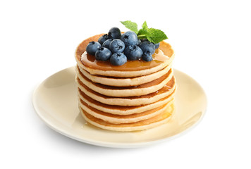 Plate with pancakes and berries on white background
