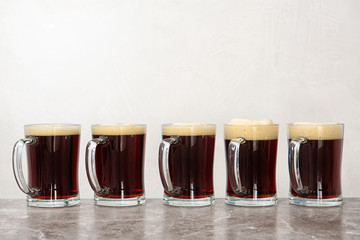 Row of glass mugs with beer on table