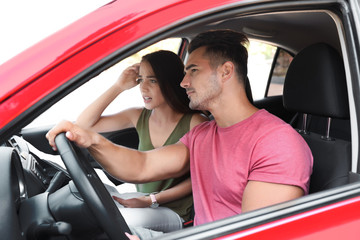 Young couple with map in car on road trip
