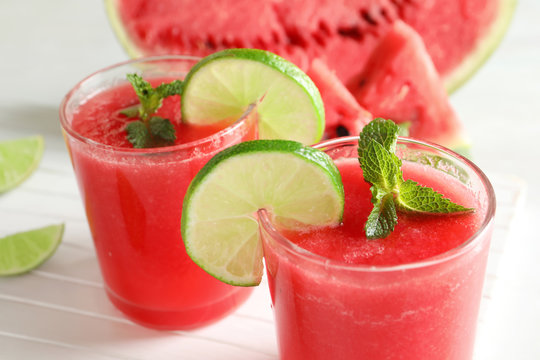 Tasty summer watermelon drink with lime and mint on table, closeup