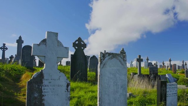 Nice timelapse of clouds moving over old headstones in a cemetery or graveyard.