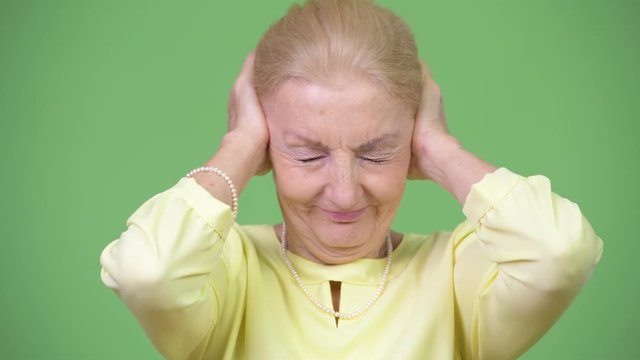 Beautiful senior businesswoman covering ears as three wise monkeys concept