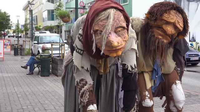 Two giant troll figures stand on the streets of Akureyri, Iceland.