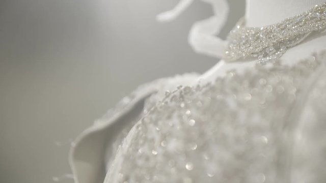A white lacy dress on a female mannequin. Dettail of a wedding gown with necklace made of pearls. Fashion concept.