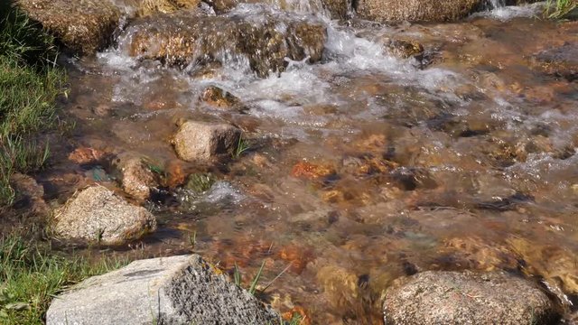 Clear water flow, rocky river closeup. Flowing water of creek in mountain valley