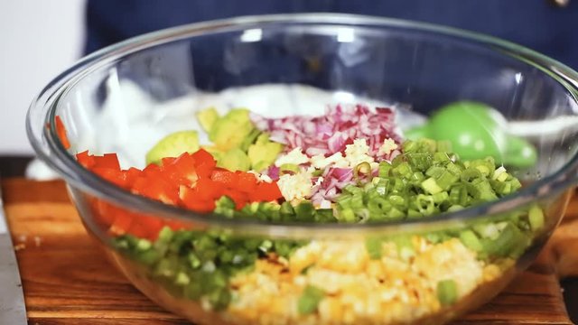 Step by step. Squeezing garlic into traditional mexican street corn salad