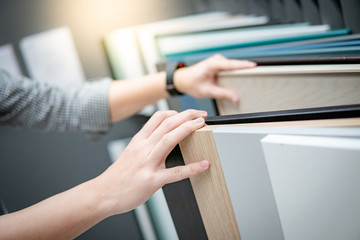 Male hand choosing cabinet panel materials or countertops for built-in furniture design. Shopping...