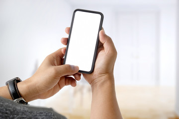 Close up of a man using blank screen mobile smart phone over blurred bokeh background.