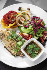tilapia fish fillet with mixed salad and grilled vegetables