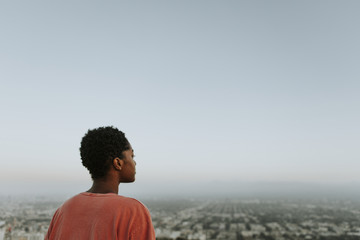 Woman looking out over the city - obrazy, fototapety, plakaty