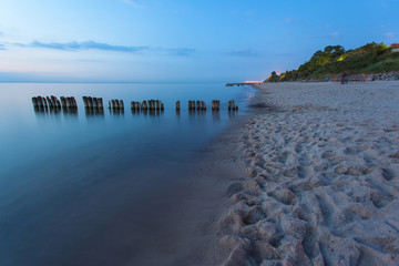 Fototapeta premium smooth sea surface and coast in blue twilight on long exposure