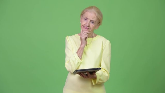 Beautiful Senior Businesswoman Using Digital Tablet And Thinking