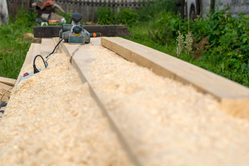 electric woodworking tools lying on the lumber outdoors