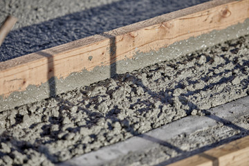 Wet Cement with a 2x4 wood to level it