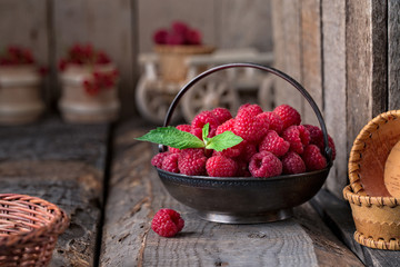 Rural still life with raspberries on rustic wooden  table