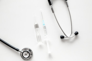Infuenza vaccine in syringe near stethoscope on white background top view copy space