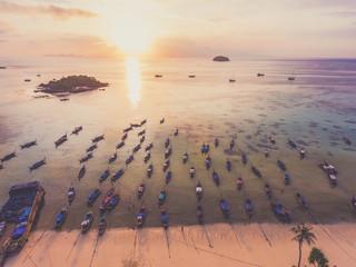 Aerial view over group of long tail boats with beautiful sea and beach.