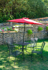Obraz premium Outside cafe table on green lawn under the red canopy
