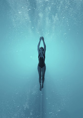 Woman swimming underwater in a sea.