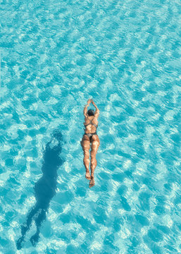 Woman swimming in swimming pool.