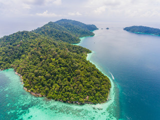 Aerial view over group of long tail boats with beautiful sea island and beach.