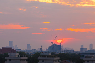 Fototapeta na wymiar Aerial View Construction Cranes Silhouette over Construction Site on Amazing cityscape at Sunset Sky.