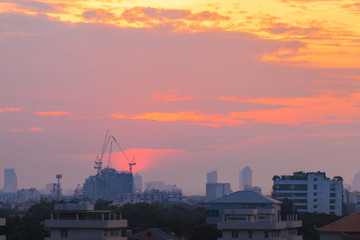 Aerial View Construction Cranes Silhouette over Construction Site on Amazing cityscape at Sunset Sky.