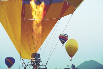 Obraz premium Close-up of hot air balloons with fire blue sky background applying retro and vintage filter effect styles.