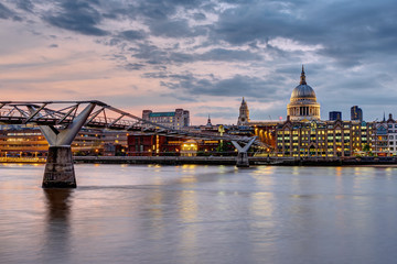 The Millennium Bridge and St. Paul's cathedral in London, UK, at sunset