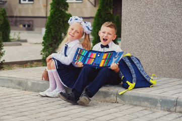 Primary school pupil. Children with backpacks near the school building . Beginning of the school...