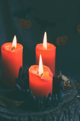 Three red burning candles on black candlestick. Decoration for Halloween party. Funny october holiday. Copy space for text.
