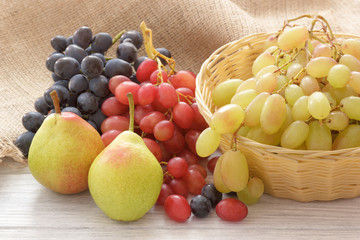 Rustic fruits pears and grapes on white wooden table