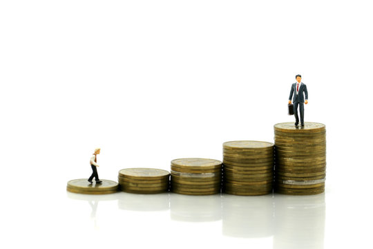 Miniature people : young businessman standing on stack of coins with Successful businessman,Business Growth concept.